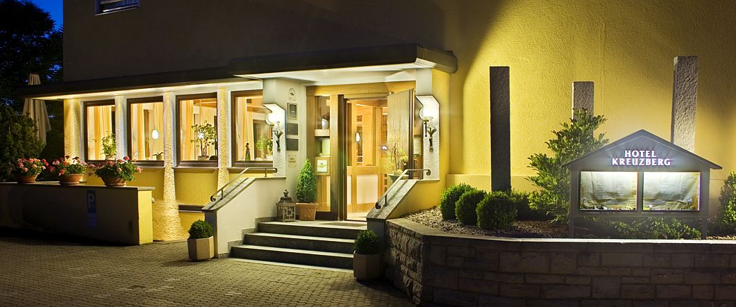 Der einladend beleuchtete Eingang des Hotel Kreuzberg am Abend